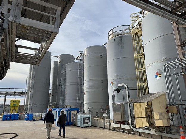 Operators inspecting FRP chemical storage tanks on site
